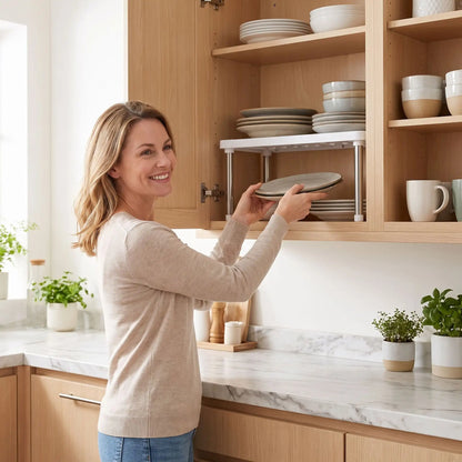 femme installant une etagere placard cuisine extensible blanc et rangeant ses assiettes sur deux niveaux